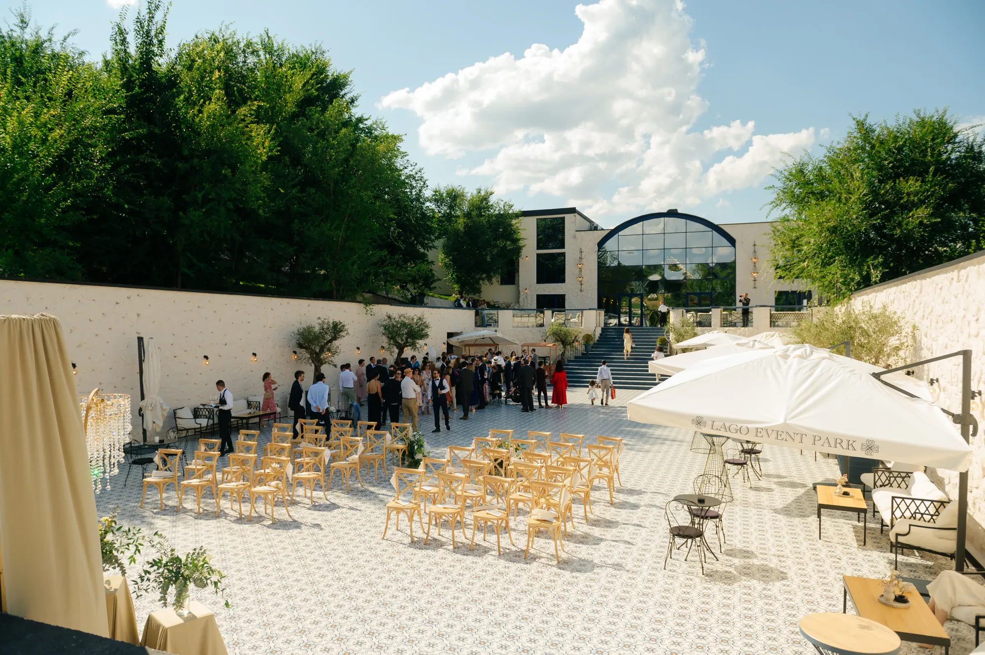 Curtea Lago Event Park pregătită de ceremonie, cu invitați și umbrele albe
