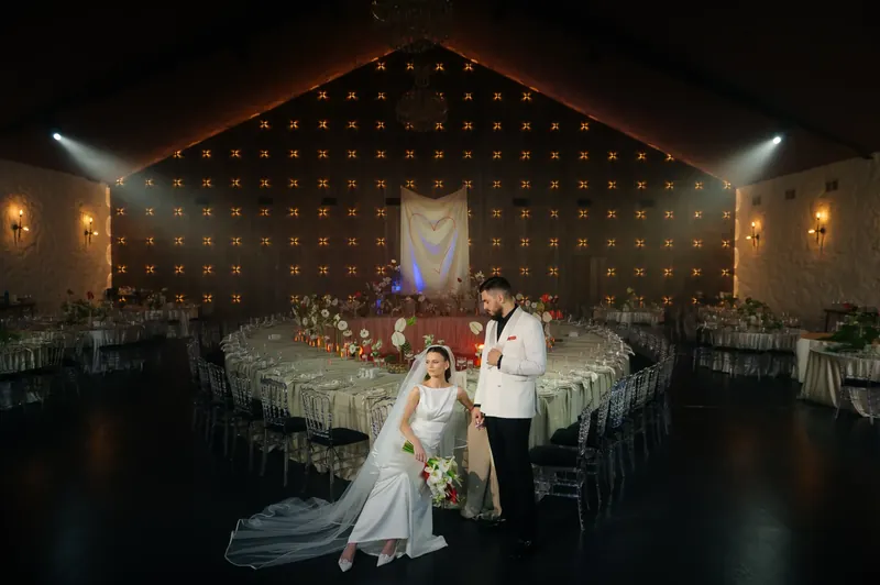 Mirii în sala festivă, cu perete luminat și prezidiu decorat cu flori