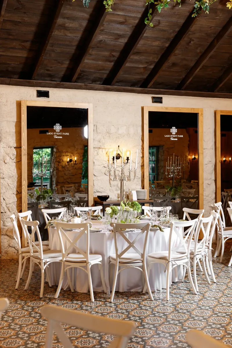 Masă rotundă cu sfeșnic argintiu în sala Toscana, cu oglinzi mari