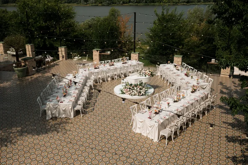 Terasă cu vedere la lac, mese aranjate festiv în jurul pianului alb